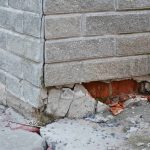 Selling A House With Foundation Issues: Full Guide From Real Estate Experts A house with visible brick exterior foundation issues