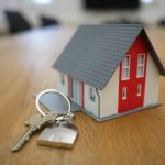 How To Protect Yourself When Selling A Home? A house key and miniature house