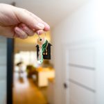 How Much Cleaning Should You Do When Selling A Home? A person holding a house key for a home for sale.