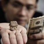 What Are The Benefits Of Selling A House For Cash? A person holding money and a miniature house.