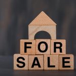 Why Wait 5 Years To Sell A House? Discover The Reasons sell a house concept with wooden cubes, wooden home grey