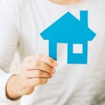 Can You Sell Your House While You Still Living In It? man holding a blue paper selling your house