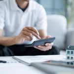 Do You Really Have To Pay Taxes On A Cash Home Sale? A person computing taxes in a cash home sale