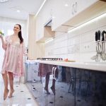 What Upgrades Increase Home Value? Modern kitchen upgrade with happy woman to increase home value.
