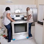 Men installing new appliances before selling house