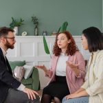 A woman accompanied by her friend, talking to a real estate lawyer