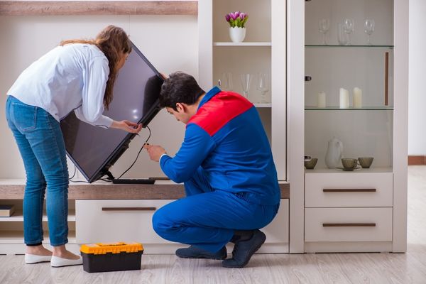 Woman and repairman checking appliance function