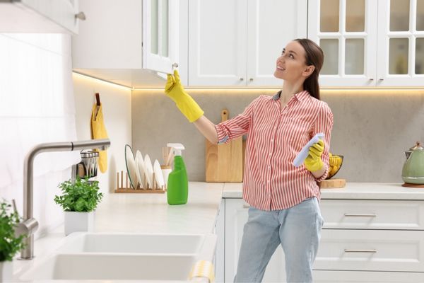 Woman performing deep kitchen cleaning task