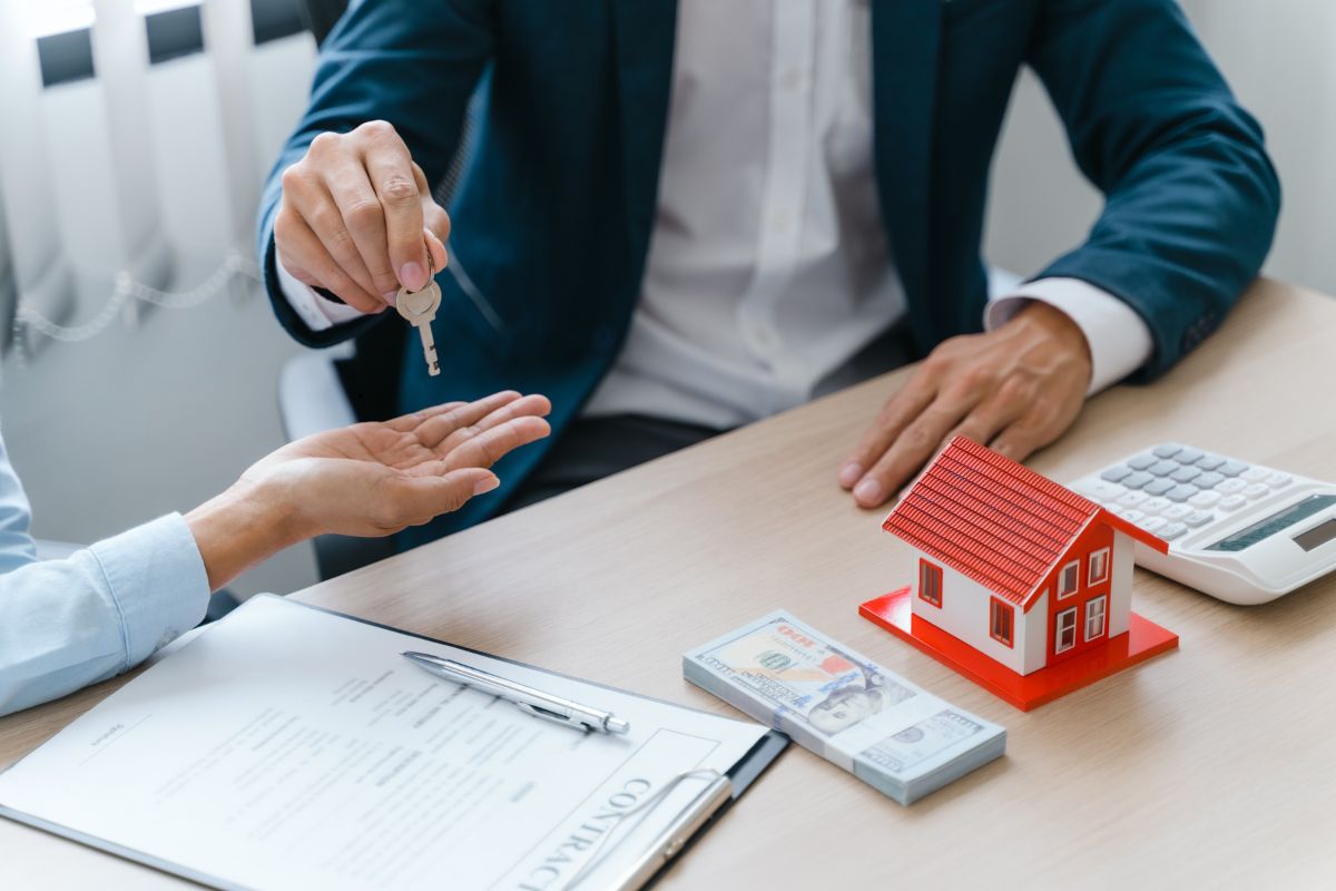 Agent giving the keys to buyer after selling a house.