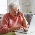 7 Costly Mistakes When Selling Your Home Without An Agent (And How Cash Buyers Solve Them) Elderly woman speaking on the phone about selling her home.