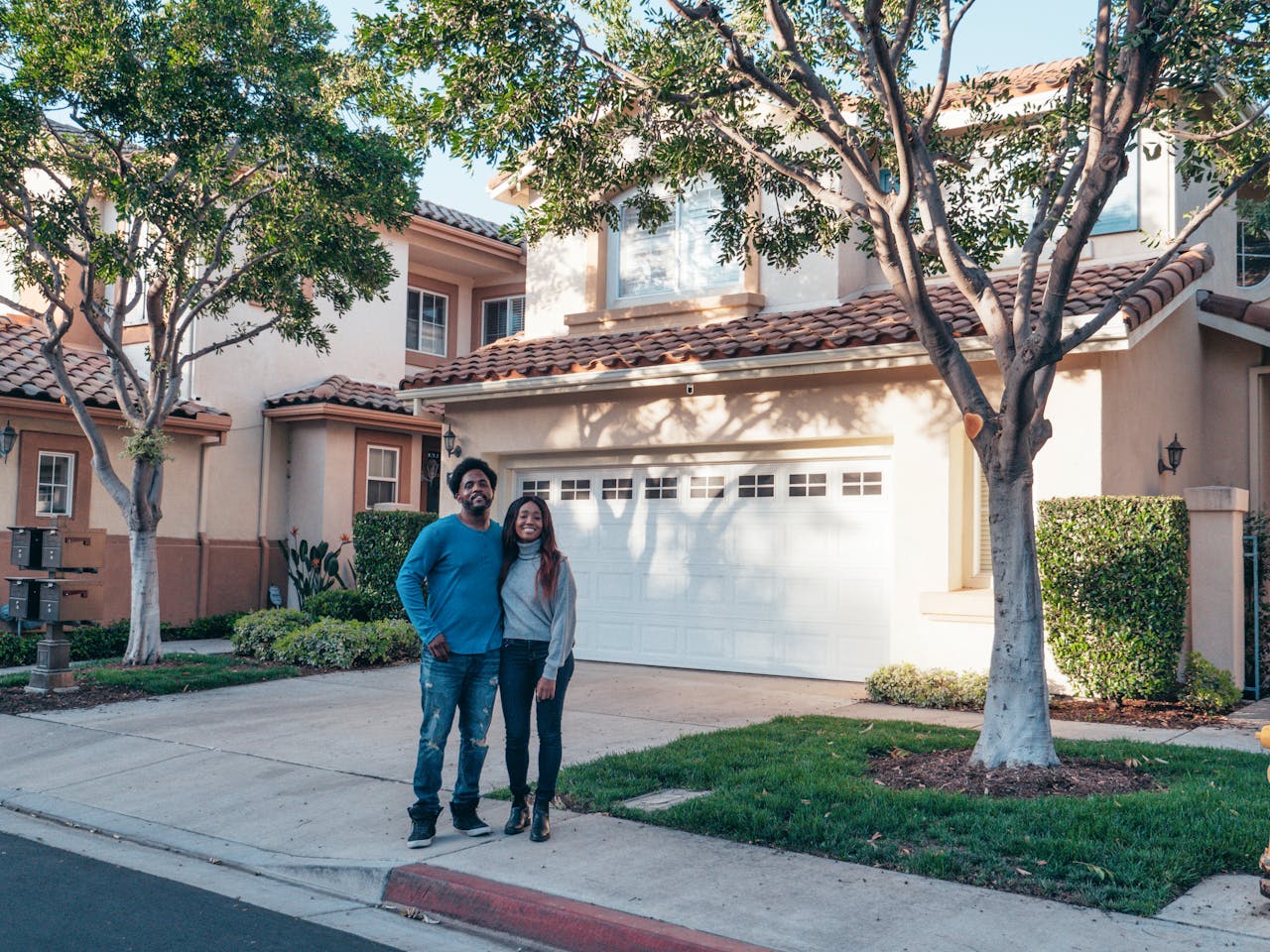 A couple happily posing for a photo after purchasing their new home