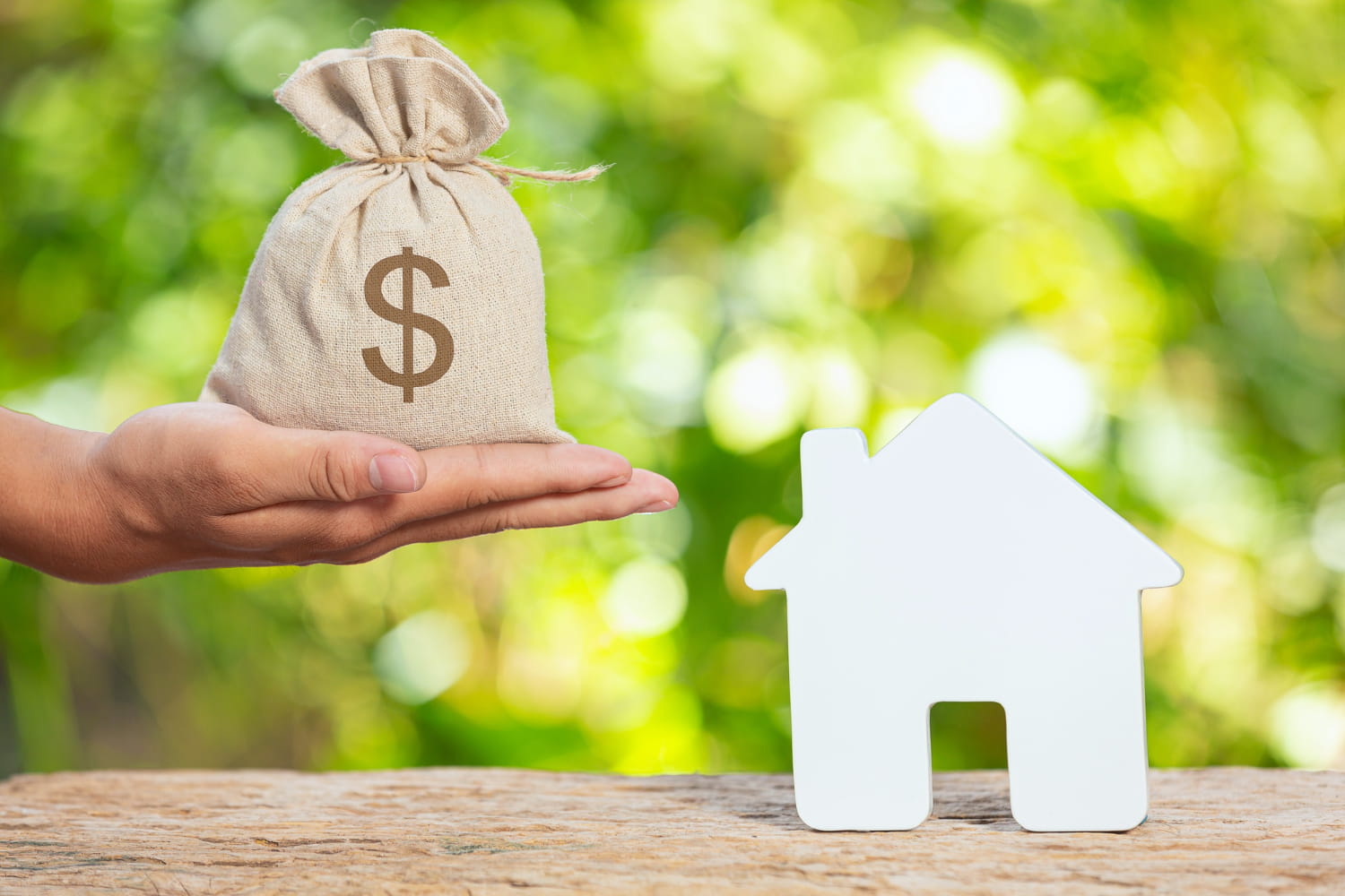 A person holding a sack of money in exchange for a house