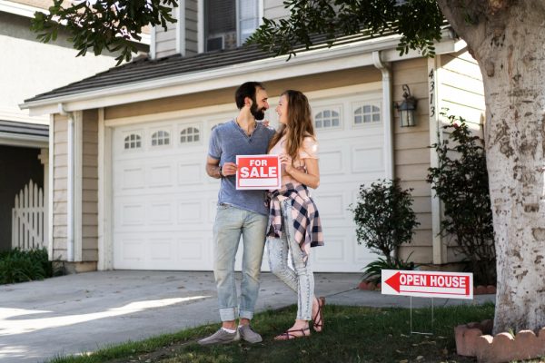 Homeowners Posting For Sale Sign on Their Property
