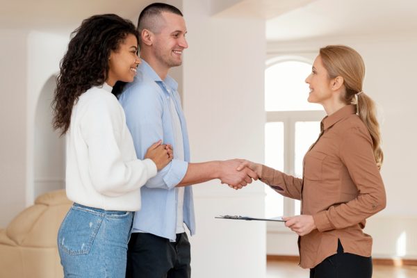 Couple handshaking with home buyer